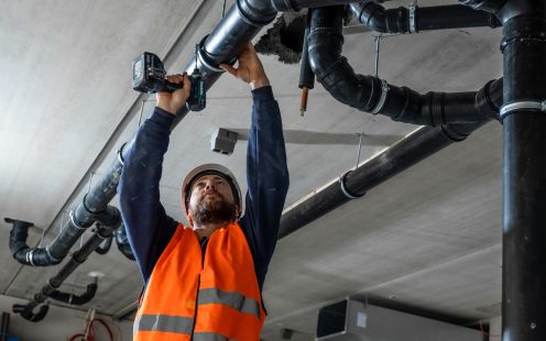 Santehniķis uzstāda cauruļvadu sistēmu ēkas iekšējiem tīkliem