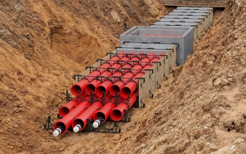 A 3D visualization of a duct bank system being installed in an open trench. 