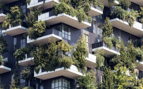A corner of a modern multi-storey building with panoramic windows and extensive greenery on balconies | Pipelife