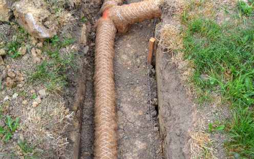 Drainage pipe in trench near farm